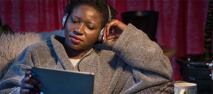 Woman wearing headphones on laptop
