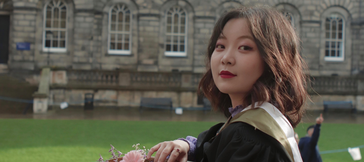 Photo of Yixiang Shirley Lin on graduation day standing outside Old College