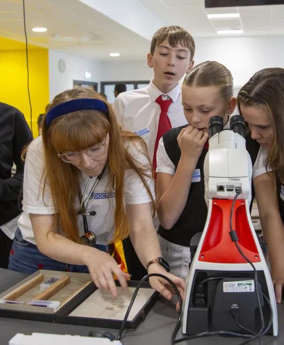 You Can Be A Doctor's Paula Glancy showing Castlebrae S1 pupils how to use a microscope