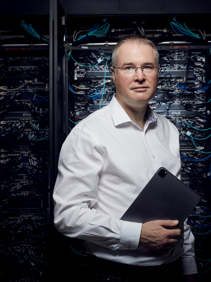 Mark Parsons, Professor of High-Performance Computing and Associate Dean for e-Research, pictured with ARCHER2