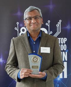 Photo of Ram Ramamoorthy holding trophy for Top 100 Asian Stars in UK Tech