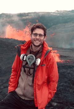 Image of Dr Eric Breard standing in front of a volcano in Iceland