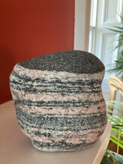 Photograph of 2.8 billion years old rock and is called Lewisian gneiss sitting on a table.