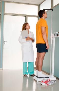 Physician measuring a man's height