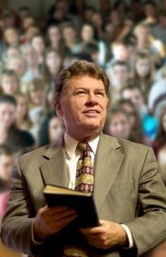 Composite shot. Foreground: Michael Gott with Bible. background: large congregation