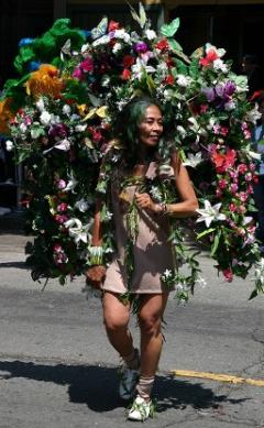 Photograph of a woman with a flower arch taken at the Carnival Parade in the Mission District of San Francisco over the Memorial Day weekend in May 2008.