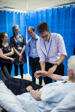 A simulated patient being examined by medical students