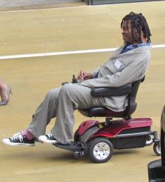 A photograph of Yinka Shonibare sitting in his wheelchair. 