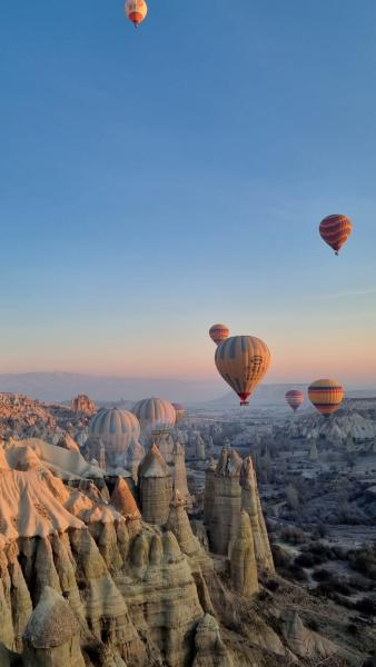 Sunrise in Cappadocia. Hundreds of hot air balloons float over the unique landforms of Cappadocia.