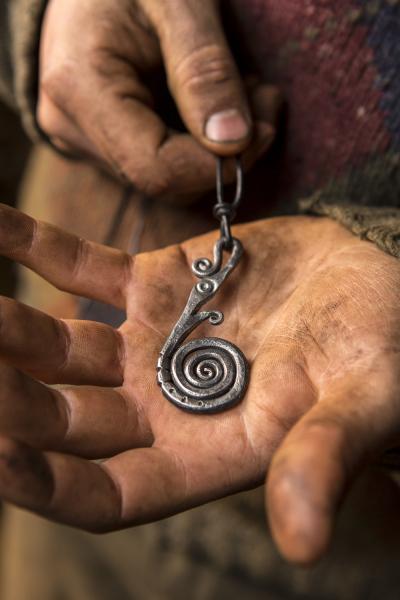 Hands displaying a spiral pendant