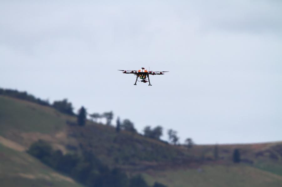 T680 drone in flight with trees and hills behind