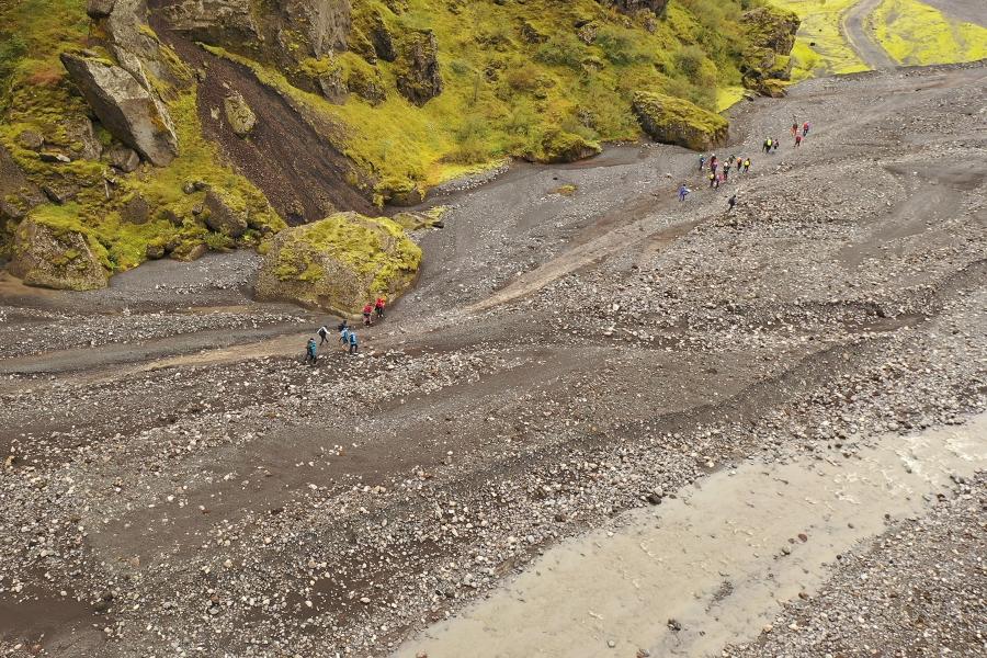 group of students walking along a river channel in iceland
