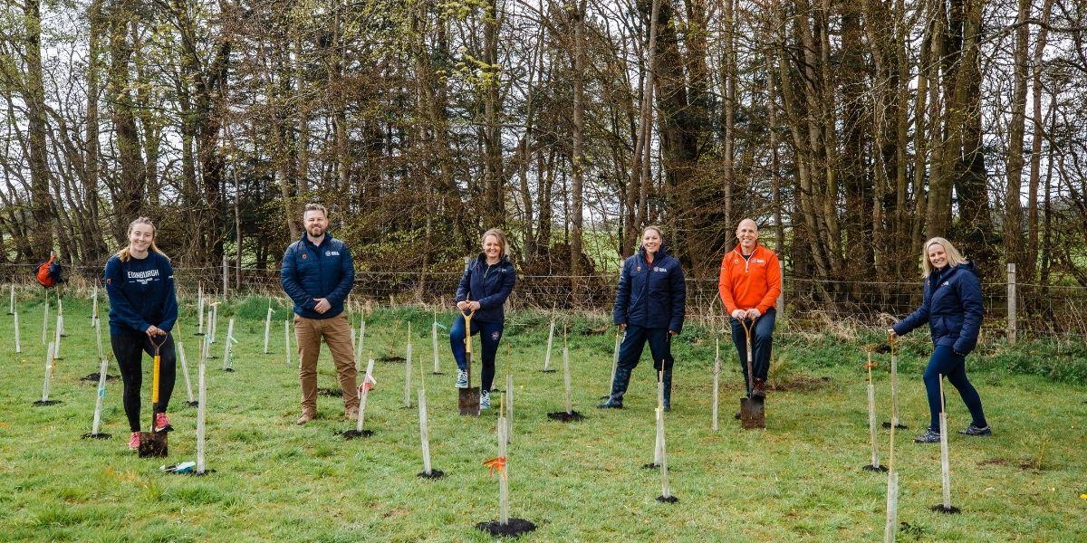 Group of people attending standing beside newly planted trees