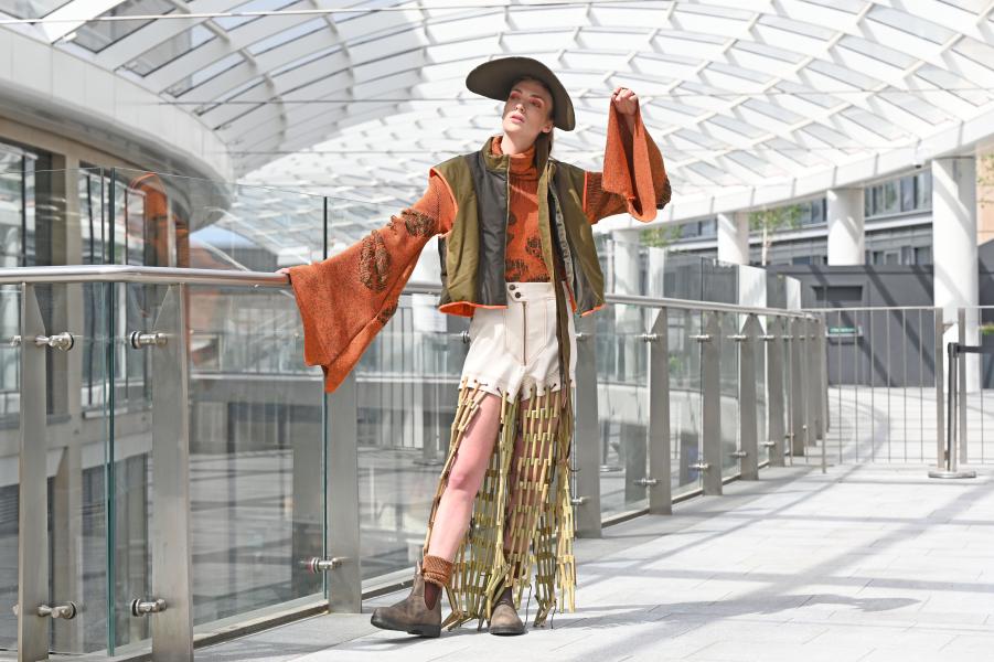 A model poses next to a glass banister