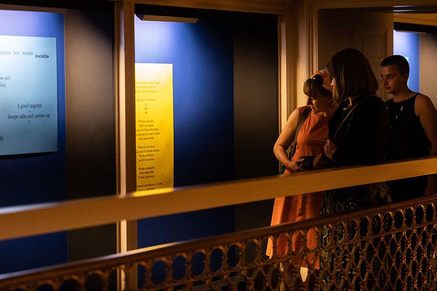 Photo of a group of visitors to Talbot Rice Gallery looking at one of the panels from the exhibition the nature of difference