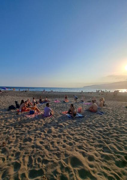 People on a beach doing yoga