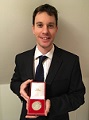 Photo of Alastair Hayes holding his Lord Smith medal
