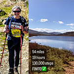 Woman hiking by loch with '54 miles, 19 hours, 130,000 steps, finito' written in front