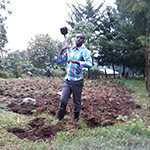 Collins Cheruiyot digging with a shovel