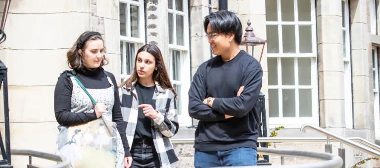 three students talking at doorway
